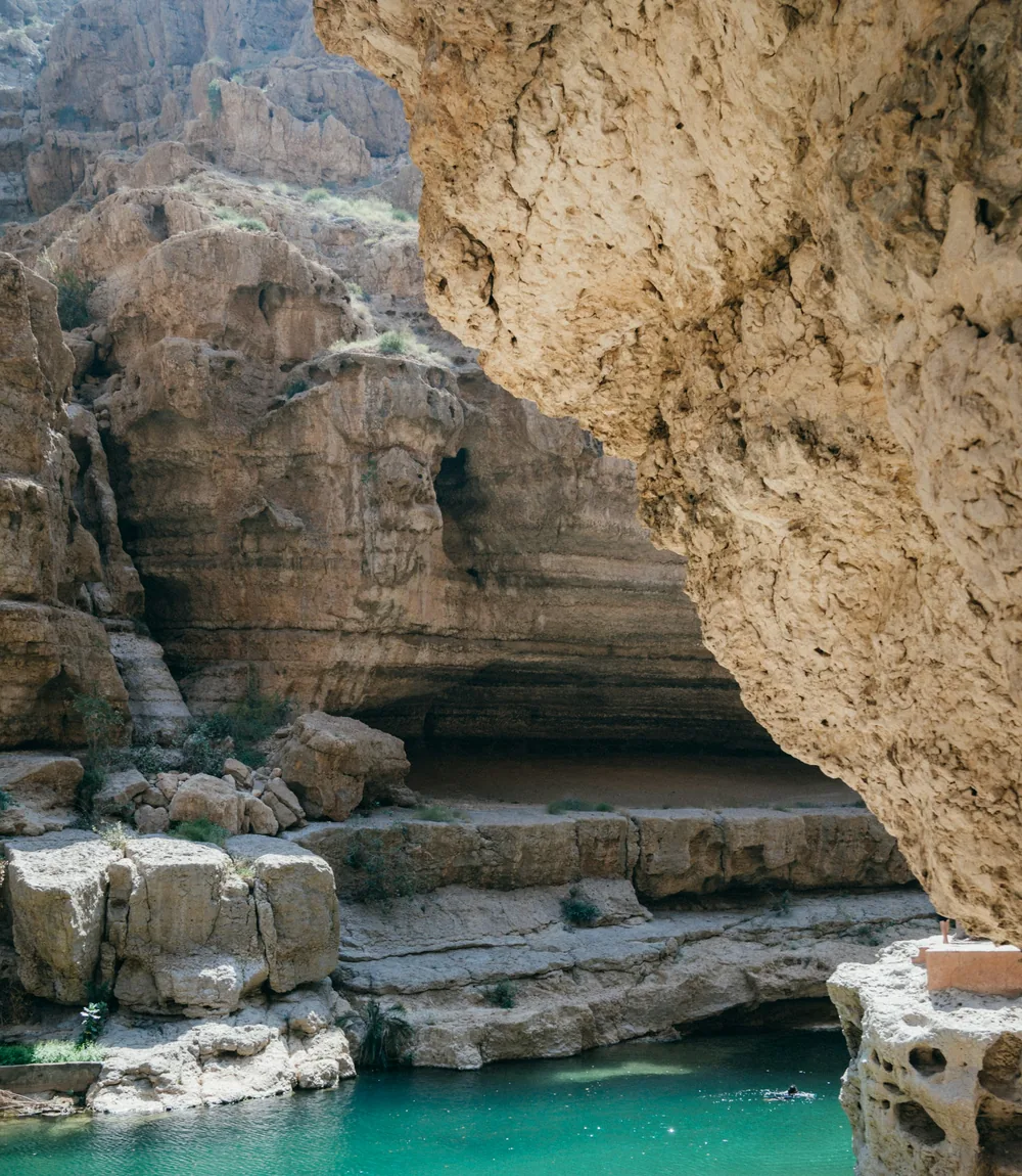 Steep limestone fjord cliffs meeting turquoise sea in Musandam